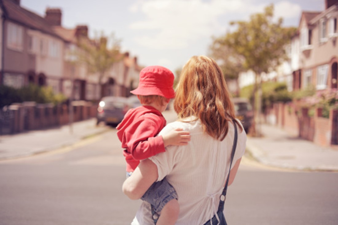 Mother with son looking down suburban road